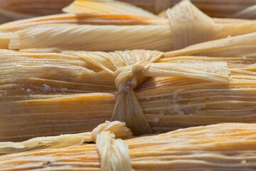 Fresh tamales closeup corn husk tied details Mexican food Hispanic cooking.