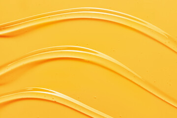 Oil gel texture background. Vitamin C serum, yellow skincare gel cream close up