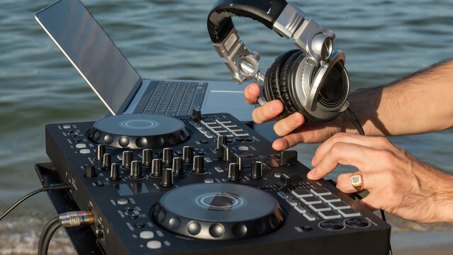 Close up of DJ's hands while working outdoors.  - Powered by Adobe