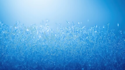 Delicate frost patterns forming on a cold glass surface with shimmering blue light