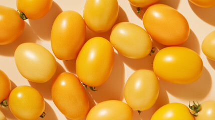 Freshly harvested yellow tomatoes on a light background