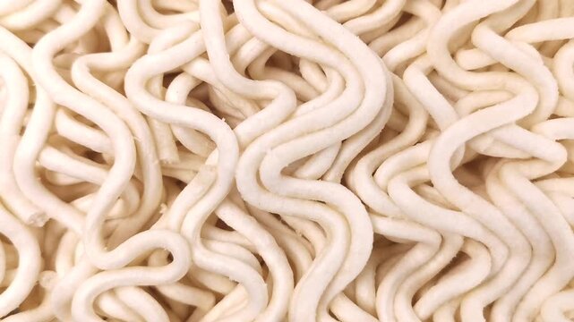 Close-up footage of uncooked noodles featuring detailed curved textures, captured with smooth camera movement to highlight natural patterns, shapes, and structure, ideal for culinary visuals