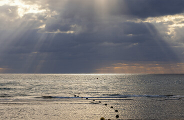 Beautiful sunset on the Mediterranean Sea with dark clouds and sun rays