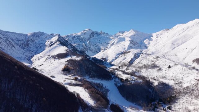 Aerial Wide drone fly Italian snowed alps winter mountain range under blue sky