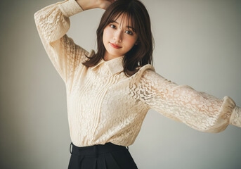 上品なレースブラウスを纏い優雅なポーズで佇む女性