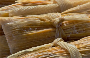 Fresh tamales closeup corn husk tied details Mexican food Hispanic cooking.
