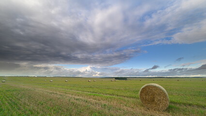 A Beautiful and Picturesque Rural Landscape Featuring Dramatic Clouds and Large Hay Bales