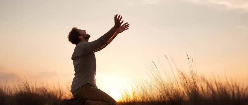 Man kneeling with raised hands, symbolizing faith, spirituality, hope, gratitude, and a deep personal connection with the divine.