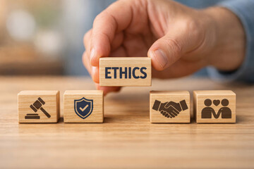 Hand placing wooden block with ethics word showing marketing business concept about building trust with honest integrity table with icon symbols