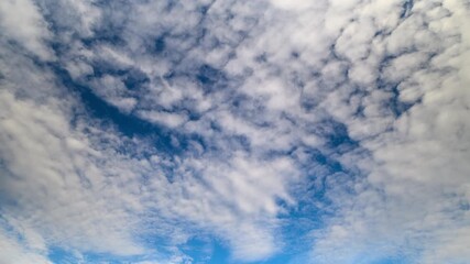 Serene sky display, Gentle cloud layers complement blue, Calm atmospheric view features tiered cloud shapes, Peaceful sky scene decorated with stratified fluffy cloud formations