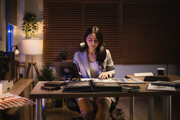 An interior designer studies color and material swatches at her desk, planning a stylish home design project in a cozy office