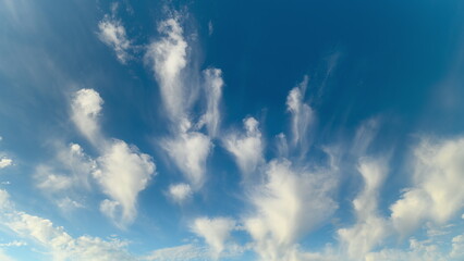 Serene azure sky with drifting clouds, Gentle clouds drift across vast blue horizon, Bright sky features delicate clouds moving peacefully amidst blue background © beholdereye
