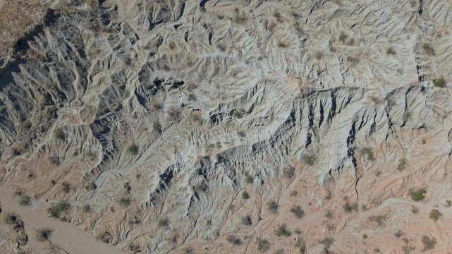 Straight down aerial drone view showcasing intricate topography and ancient water patterns carved into the Tatacoa Grey Desert revealing detailed erosion textures natural geometry and timeless terrain