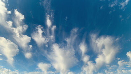 Calm clouds drift beneath sunlight, Gentle clouds drift peacefully across bright blue sky, Peaceful clouds gently illuminate vast sky as they drift under shining sun © beholdereye