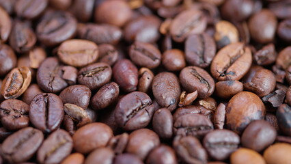 Naklejka premium Detailed roasted coffee beans image, Close view of aromatic roasted coffee beans, Close shot capturing textured roasted coffee beans with oily appearance and diverse cracks