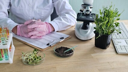 Scientist observes plant growth and soil samples in laboratory