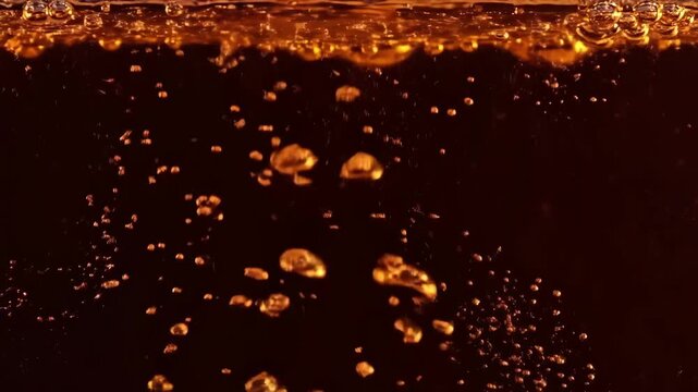 Golden bubbles rising in liquid against a dark background, a dynamic beverage texture for party drink advertisement