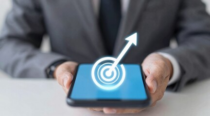 A businessman holds a smartphone displaying a growth target symbol.