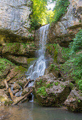 Fototapeta premium waterfall on a mountain river, natural flow of water from rocky ground, state of nature