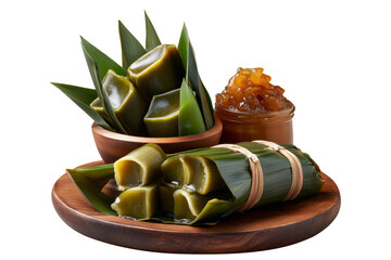 Filipino rice cakes wrapped in banana leaves with sugar sauce on wooden plate, Pandanus fruit paste, isolated on white transparent background concept. of tradition Micronesia cuisine