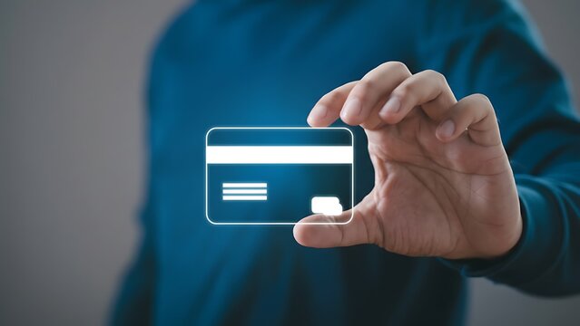 Neon-outline credit card icon held by a hand in a blue shirt; futuristic fintech concept - Powered by Adobe