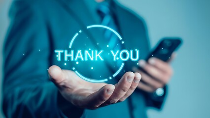 Neon blue 'THANK YOU' holographic graphic held by a businessperson in a suit with smartphone