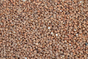 Raw buckwheat grains, Detailed image of buckwheat kernels used in cooking, Macro view of coarse buckwheat groats demonstrating rich texture and nutritional benefits for meals