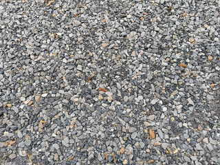 Natural gravel stone ground texture with small gray rocks, suitable for background, construction, outdoor design, and surface patterns.