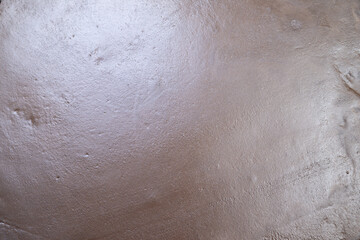 Naklejka premium Sandy shore closeup, Surface detail of beach sand, Close view of damp sandy terrain surface, Examination of moist beach earth with glimmers and ripples observed