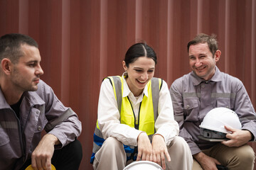 Female worker in a high-visibility vest laugh with team worker at container yard
