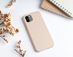 Top-down view of phone with floral sprigs and notebooks on white