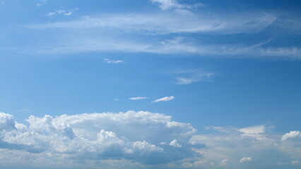 Fototapeta premium A Serene Blue Sky adorned with Fluffy White Clouds creating a peaceful and beautiful atmosphere