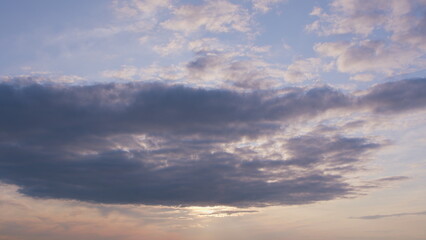 Obraz premium A Serene Evening Sky with Soft, Fluffy Clouds Arranged Against a Beautiful Dusk on the Horizon