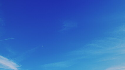 A stunning and vibrant blue sky adorned with wispy, delicate clouds floating gracefully above