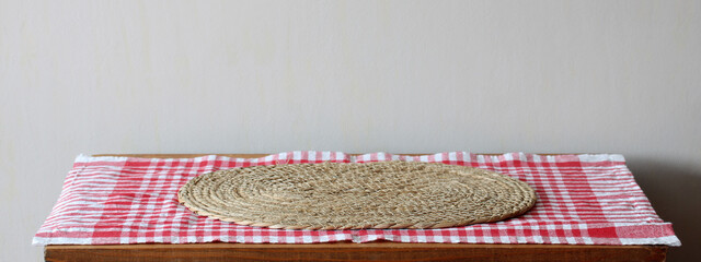 Empty wooden table with red checkered tablecloth