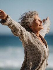 happy mature woman with arms outstretched feeling the breeze at beach beautiful middle aged woman with arms up dancing on beach mid lady feeling good and enjoying freedom at sea copy space no logos n