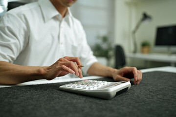 Closeup Business finance accounting banking concept. Businessman doing finances, using calculator to calculate business report on desk at office