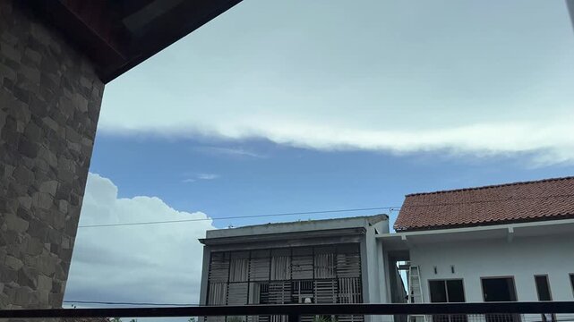 Time-lapse video footage of cloud layers above residential building architecture. Time-lapse clouds video
