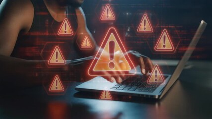 A person typing on a laptop surrounded by numerous digital warning signs, indicating a cybersecurity threat or system error. - Powered by Adobe
