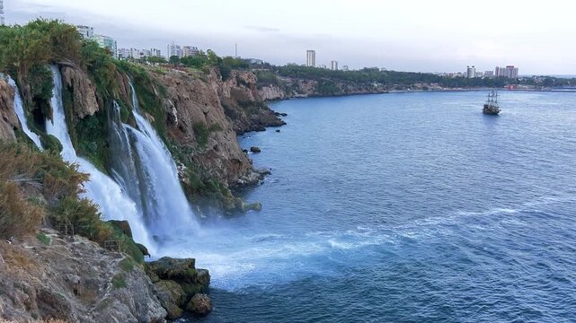View of the Nizhny Duden waterfalls in Antalya, Turkey. Waterfalls fall from a rocky cliff into the Mediterranean Sea. The cascade is formed by the Duden River, one of the rivers in southern Anatolia.