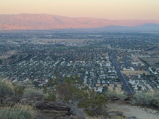 Obraz premium Little San Bernardino mountains glow orange in the setting sun beyond Palm Springs, California