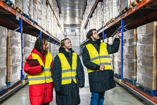 Diverse workers managing inventory in a low temperature cold storage warehouse, optimizing supply chain and distribution processes - Powered by Adobe