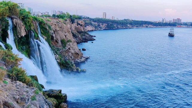 View of the Nizhny Duden waterfalls in Antalya, Turkey. Waterfalls fall from a rocky cliff into the Mediterranean Sea. The cascade is formed by the Duden River, one of the rivers in southern Anatolia.