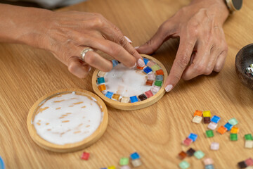 Crafting coasters and applying glue with controlled movement. Shows material awareness, calm work rhythm, and step by step artistic assembly.
