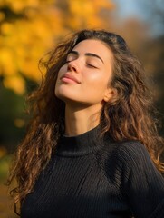 beautiful young woman relaxing at park during autumn season with closed eyes happy free natural girl breathing deeply in park with foliage in background pretty woman expressing freedom outdoor no log