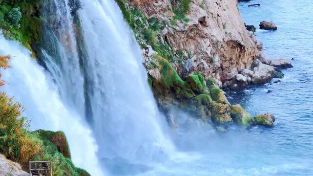 View of the Nizhny Duden waterfalls in Antalya, Turkey. Waterfalls fall from a rocky cliff into the Mediterranean Sea. The cascade is formed by the Duden River, one of the rivers in southern Anatolia.