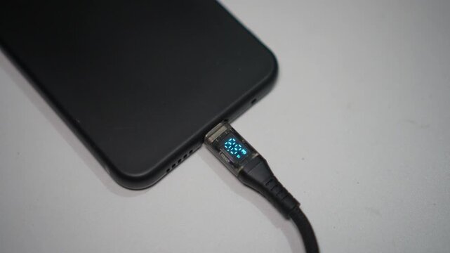 Close-up video of plugging a USB Type-C charger into a smartphone Type-C port, showing an active Power Delivery (PD) fast charging indicator.