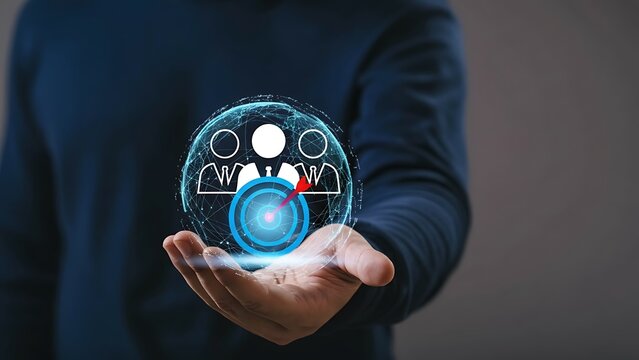 Futuristic holographic target with audience icons and interconnected network sphere held in a hand - Powered by Adobe