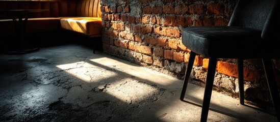 A sunlit interior with exposed brick and a dark chair