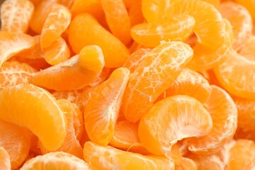 Many ripe peeled tangerines as background, top view